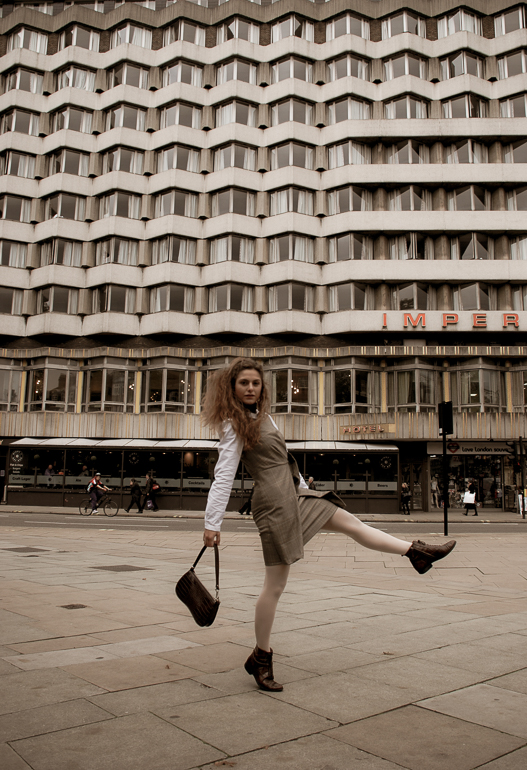 A woman is pictured against the Imperial Hotel in Russell Square, London. It is built in Brutalist style architecture.