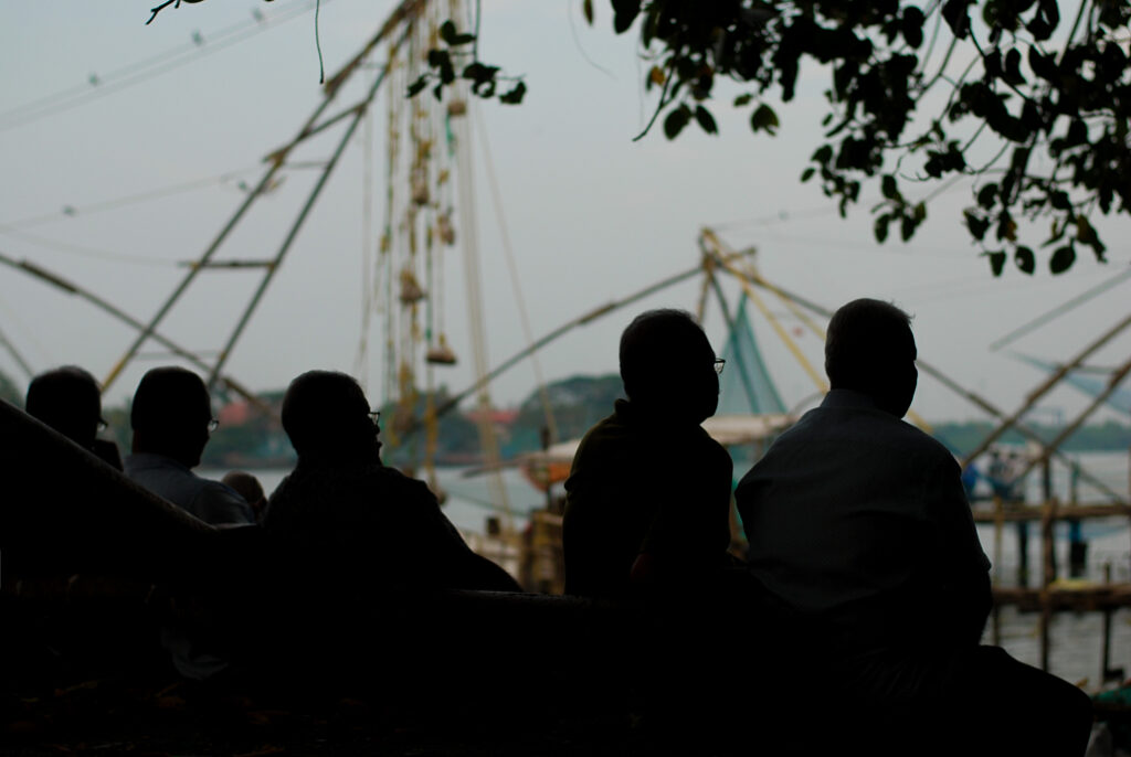 Silhouettes of five men photographed against the world famous Chinese fishing nets. Sunset, sea, shadows. Original photographs by Yuvan Kumar.