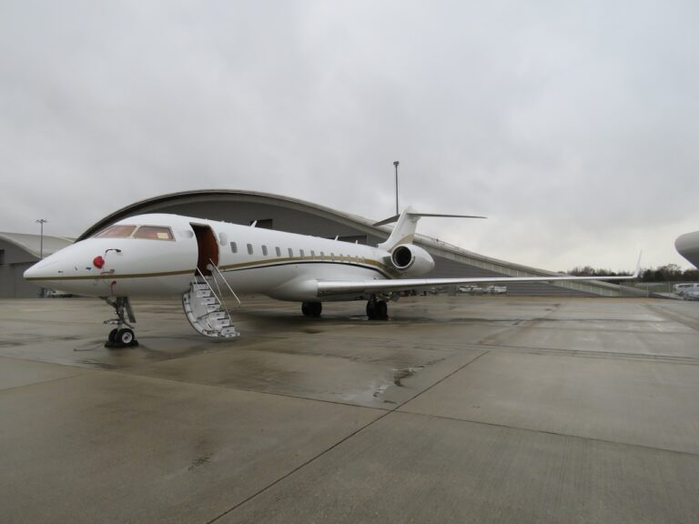 A picture of a white business jet standing on airport tarmac.